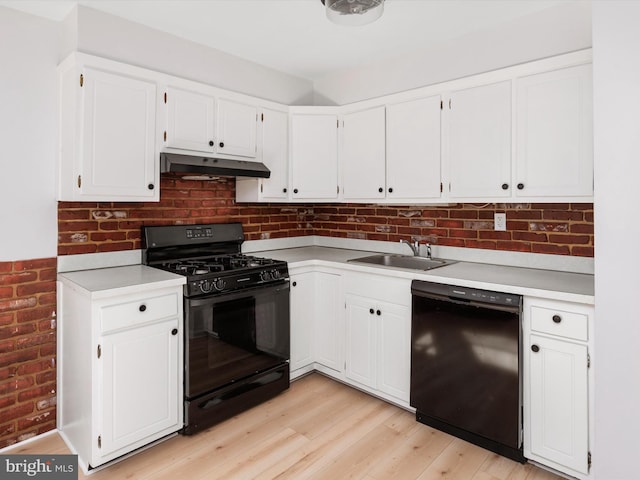 kitchen with black appliances, light countertops, white cabinets, and under cabinet range hood