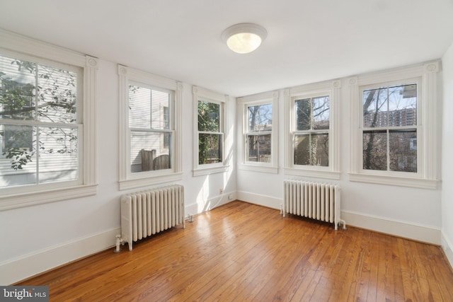 unfurnished sunroom featuring radiator heating unit and a healthy amount of sunlight