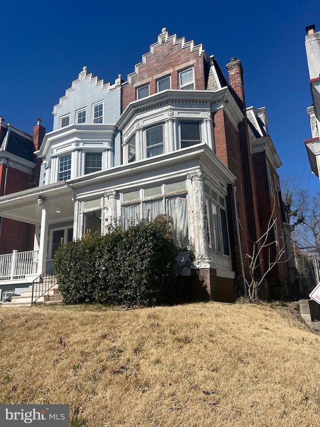 view of front of property featuring a chimney and a front lawn