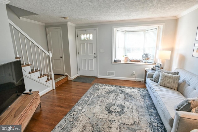 entryway featuring stairs, wood finished floors, visible vents, and ornamental molding