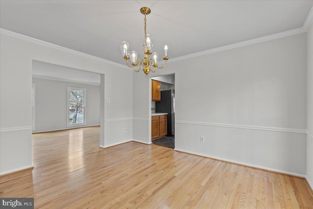 unfurnished dining area with crown molding, light wood finished floors, baseboards, and an inviting chandelier