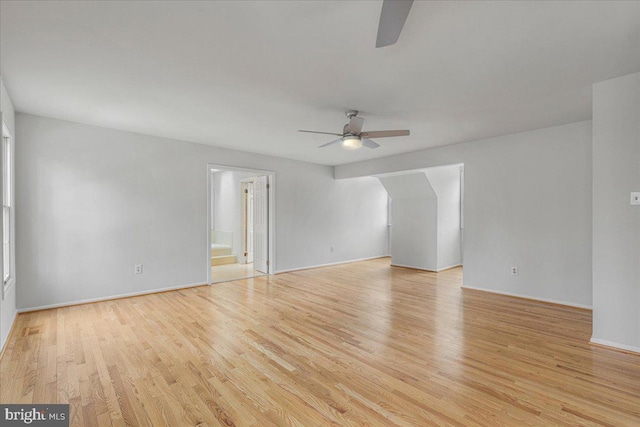 empty room with light wood-style floors, baseboards, and a ceiling fan