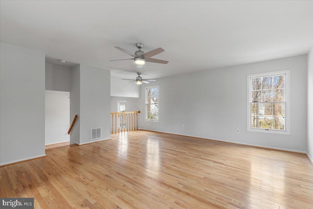 unfurnished living room featuring light wood-type flooring, visible vents, and baseboards