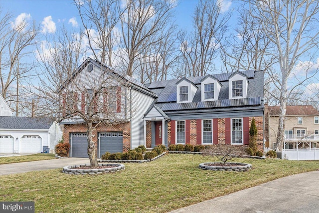 view of front of house featuring a front yard, roof mounted solar panels, brick siding, and driveway