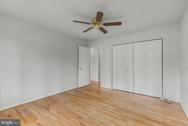 unfurnished bedroom with light wood-type flooring, baseboards, a ceiling fan, and a closet