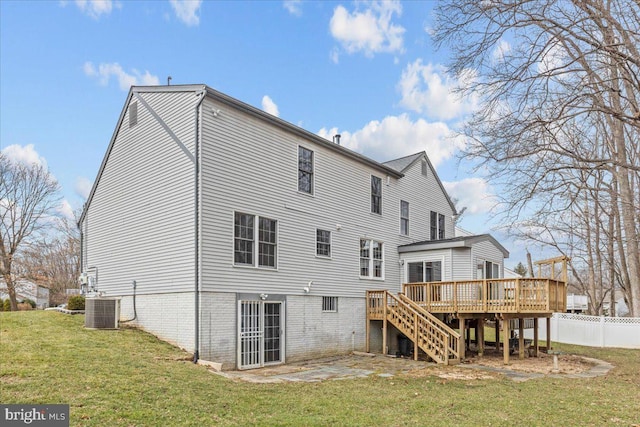 rear view of house featuring a deck, central AC unit, fence, stairs, and a lawn