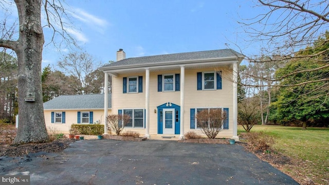 view of front of home with a chimney and a front yard