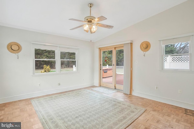 empty room featuring vaulted ceiling, plenty of natural light, and baseboards