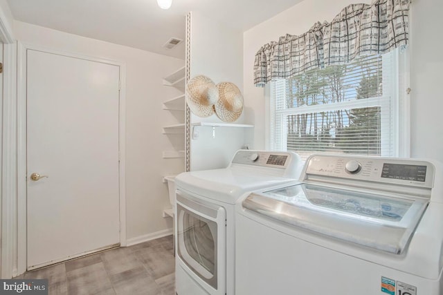 laundry area with laundry area, visible vents, and washer and clothes dryer