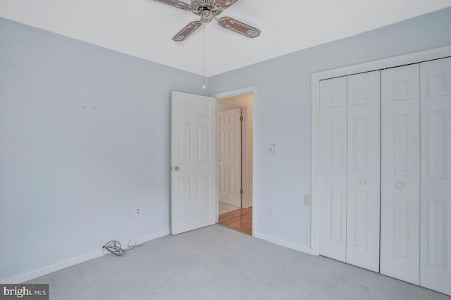 unfurnished bedroom featuring carpet, baseboards, ceiling fan, and a closet