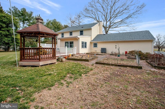 rear view of house featuring central AC, a garden, a gazebo, a lawn, and a chimney