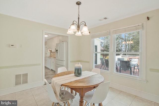 dining space featuring a chandelier, visible vents, and baseboards