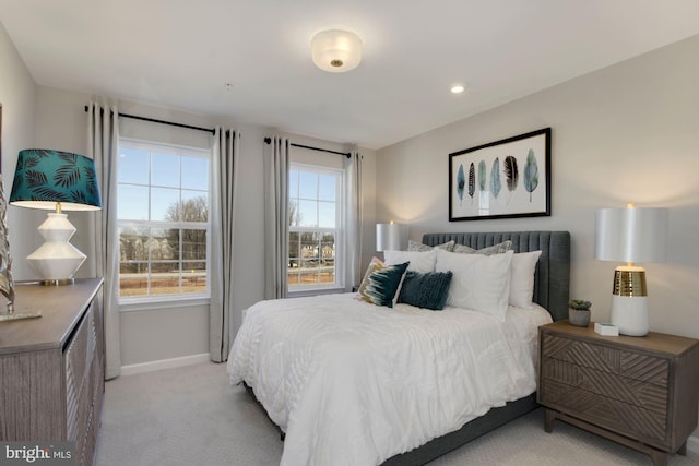 bedroom featuring light colored carpet and baseboards