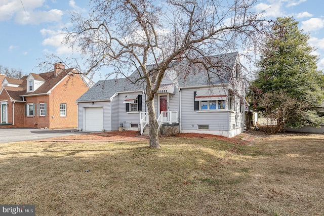 view of front of property featuring a garage, a front yard, a shingled roof, and aphalt driveway