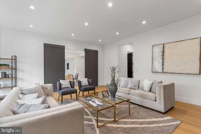 living area with baseboards, light wood finished floors, and recessed lighting