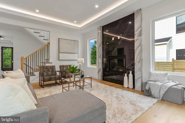 living area with recessed lighting, wood finished floors, a fireplace, and stairs