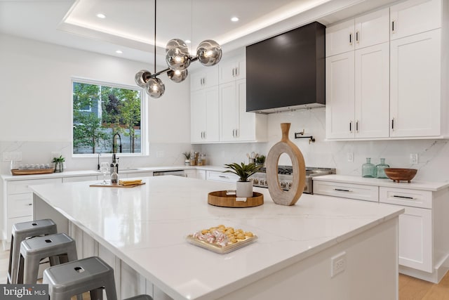 kitchen with wall chimney range hood and white cabinets