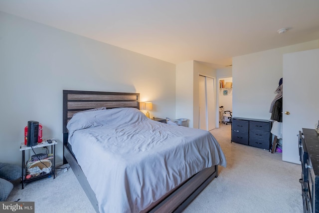 bedroom featuring light carpet and a closet