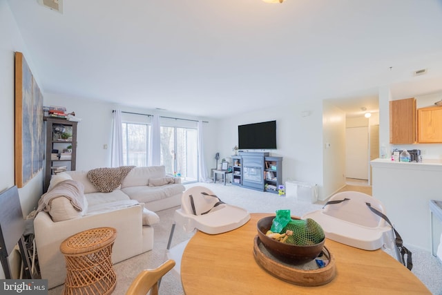 living area featuring carpet floors and visible vents