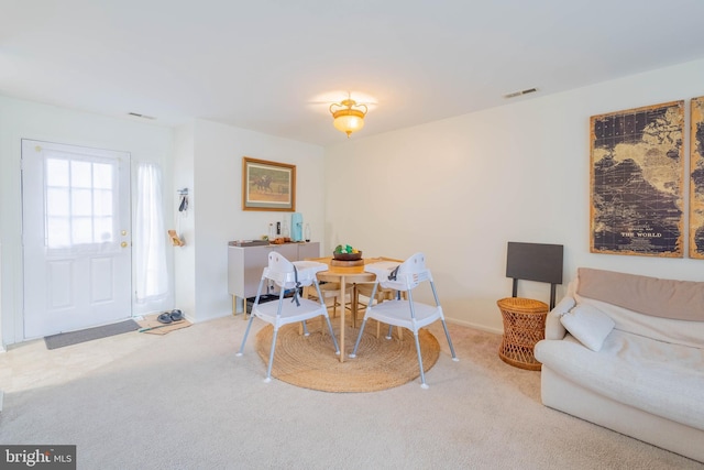 carpeted dining room featuring visible vents and baseboards