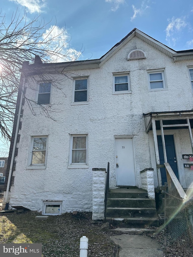 view of property featuring entry steps and stucco siding