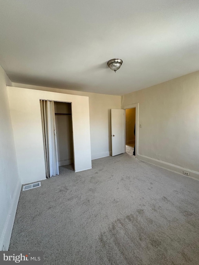 unfurnished bedroom featuring a closet, visible vents, and carpet flooring