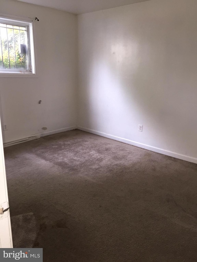 unfurnished room featuring carpet floors and baseboards