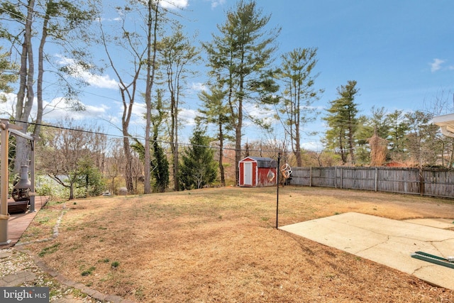 view of yard with a shed, an outdoor structure, and fence