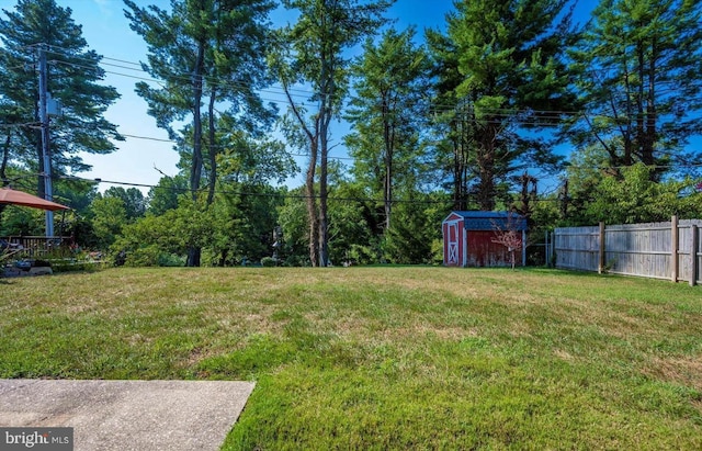 view of yard with a storage shed, fence, and an outdoor structure