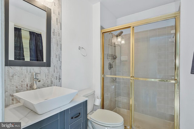 bathroom featuring toilet, a shower stall, and vanity