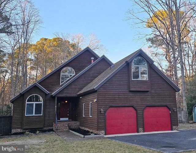 rustic home with a garage and aphalt driveway