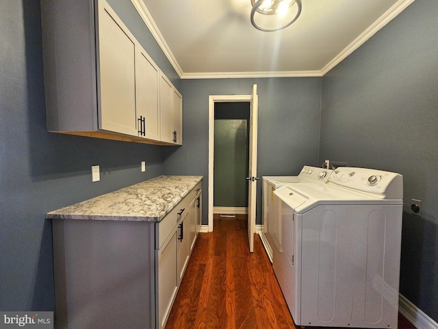 clothes washing area featuring cabinet space, baseboards, dark wood-style flooring, crown molding, and washing machine and dryer