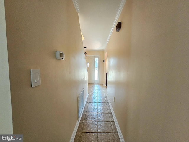 hall featuring visible vents, crown molding, and baseboards