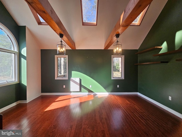 spare room featuring a skylight, baseboards, wood-type flooring, beamed ceiling, and an inviting chandelier