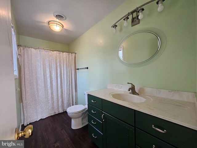 bathroom with toilet, wood finished floors, vanity, visible vents, and a shower with curtain