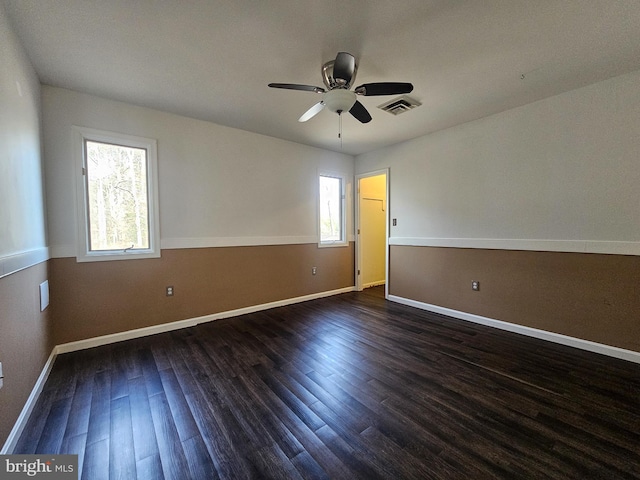 unfurnished room with baseboards, visible vents, ceiling fan, and wood finished floors