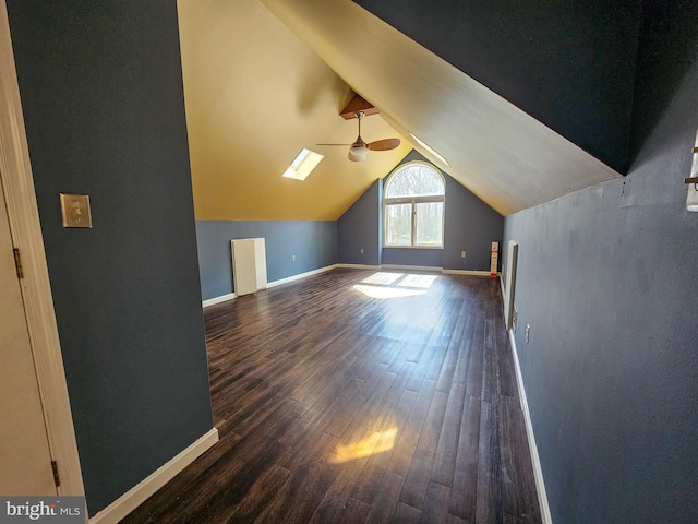 additional living space featuring lofted ceiling, dark wood-type flooring, and baseboards