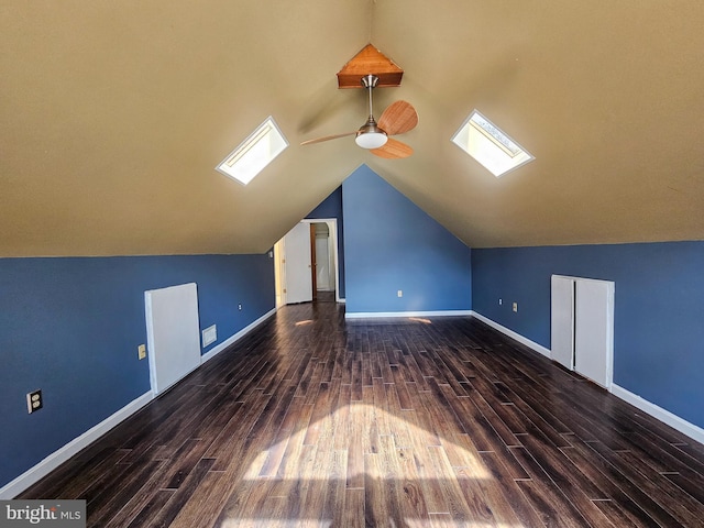 bonus room featuring ceiling fan, vaulted ceiling with skylight, wood finished floors, and baseboards