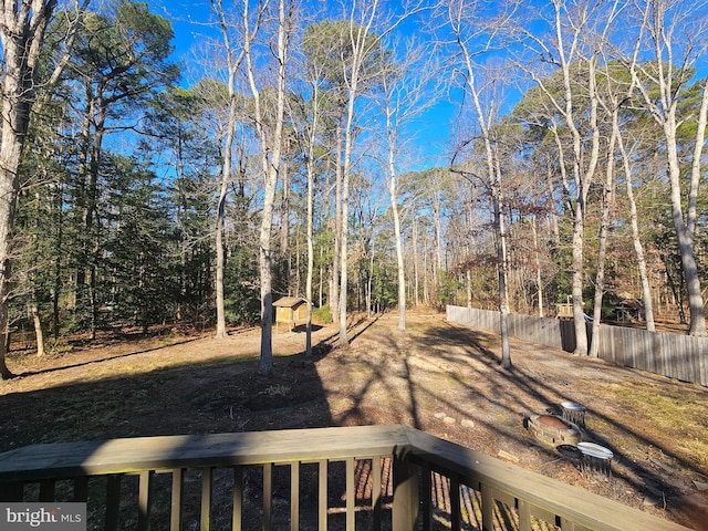 view of yard with a balcony, a storage shed, fence, and an outdoor structure