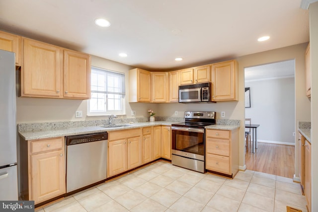 kitchen with appliances with stainless steel finishes, recessed lighting, a sink, and light brown cabinetry