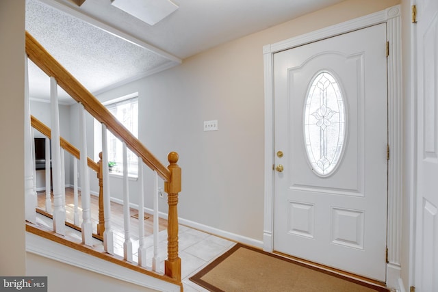 tiled foyer with stairs and baseboards