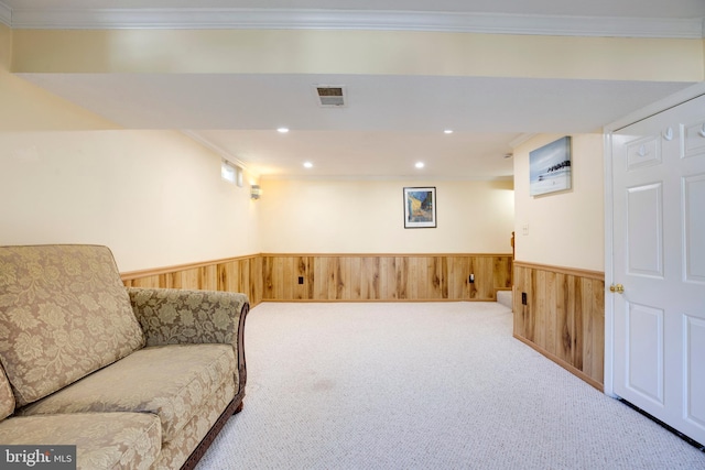 living area with crown molding, a wainscoted wall, and wood walls