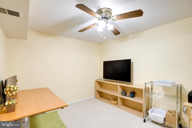 interior space featuring baseboards, visible vents, ceiling fan, and carpet flooring