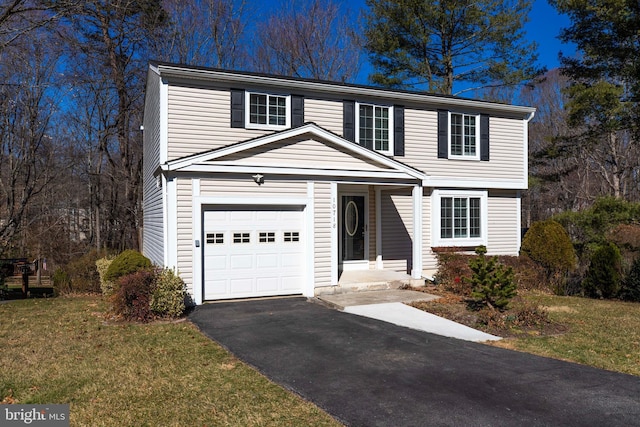 view of front of house with an attached garage, aphalt driveway, and a front yard