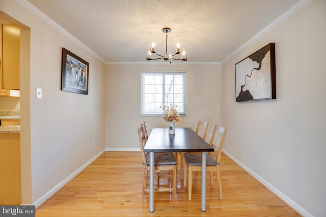 dining area with light wood-style floors, a textured ceiling, and an inviting chandelier