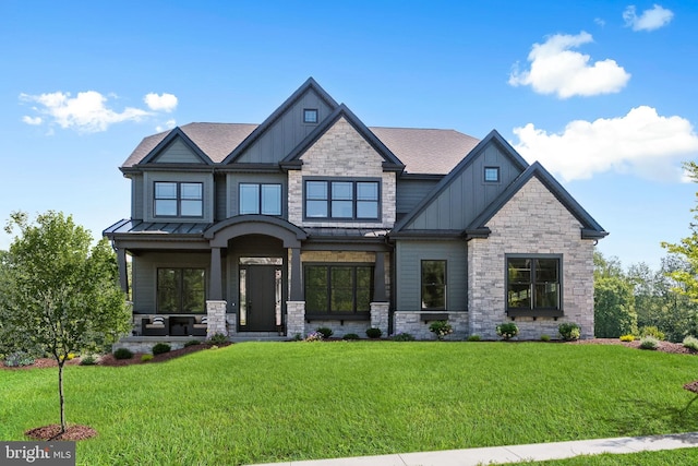 craftsman-style house with board and batten siding, a front yard, a standing seam roof, and metal roof