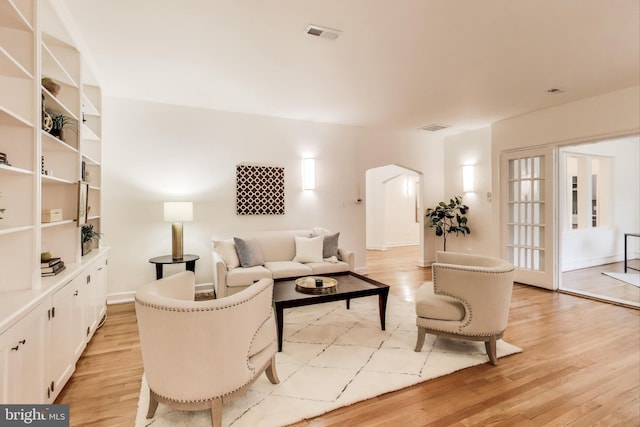 living room with visible vents and light wood-style flooring