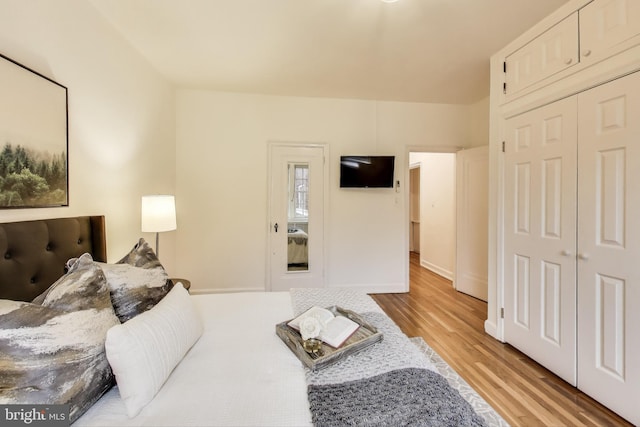 bedroom with light wood-style flooring and a closet