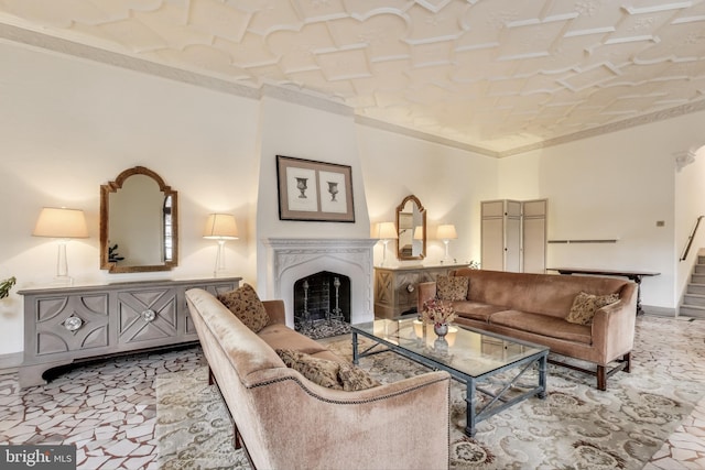 living area with stairs, a fireplace, baseboards, and crown molding