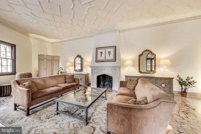 living area featuring baseboards, a fireplace, and crown molding